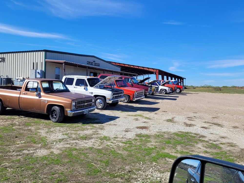 The church building and pavilion with classic trucks out front